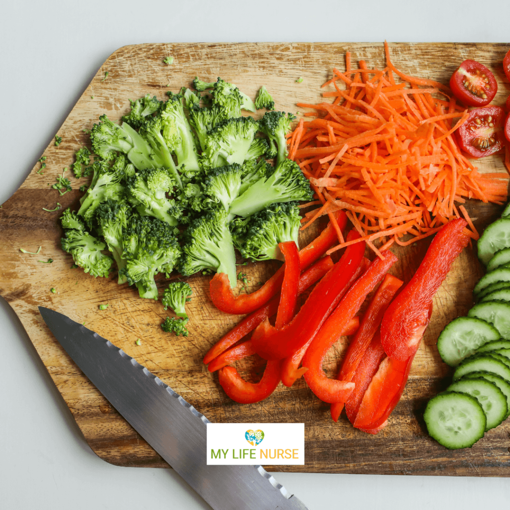 A cutting board displays a variety of freshly chopped vegetables, including broccoli, carrots, red bell peppers, cherry tomatoes, and cucumber, with a text overlay that reads, "How to Try New Vegetables When You Hate to Eat Veggies."