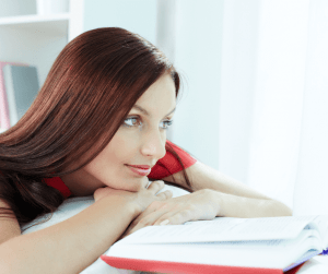 woman resting her head on a book