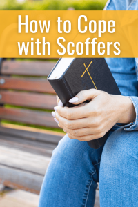 close up of woman's hands holding her Bible in your lap in prayer for post 3 Ways Scoffers Give us Courage in Ministry