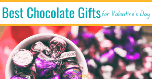 Chocolate kisses wrapped in purple and maroon and pink foil in a white candy dish with a Valentine's Day ribbon (red with white hearts) for article Best Chocolate Hershey Valentine's Day Gifts & Treats